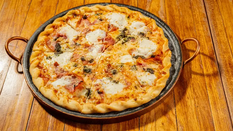 Pizza inteira servida à mesa na Saucker