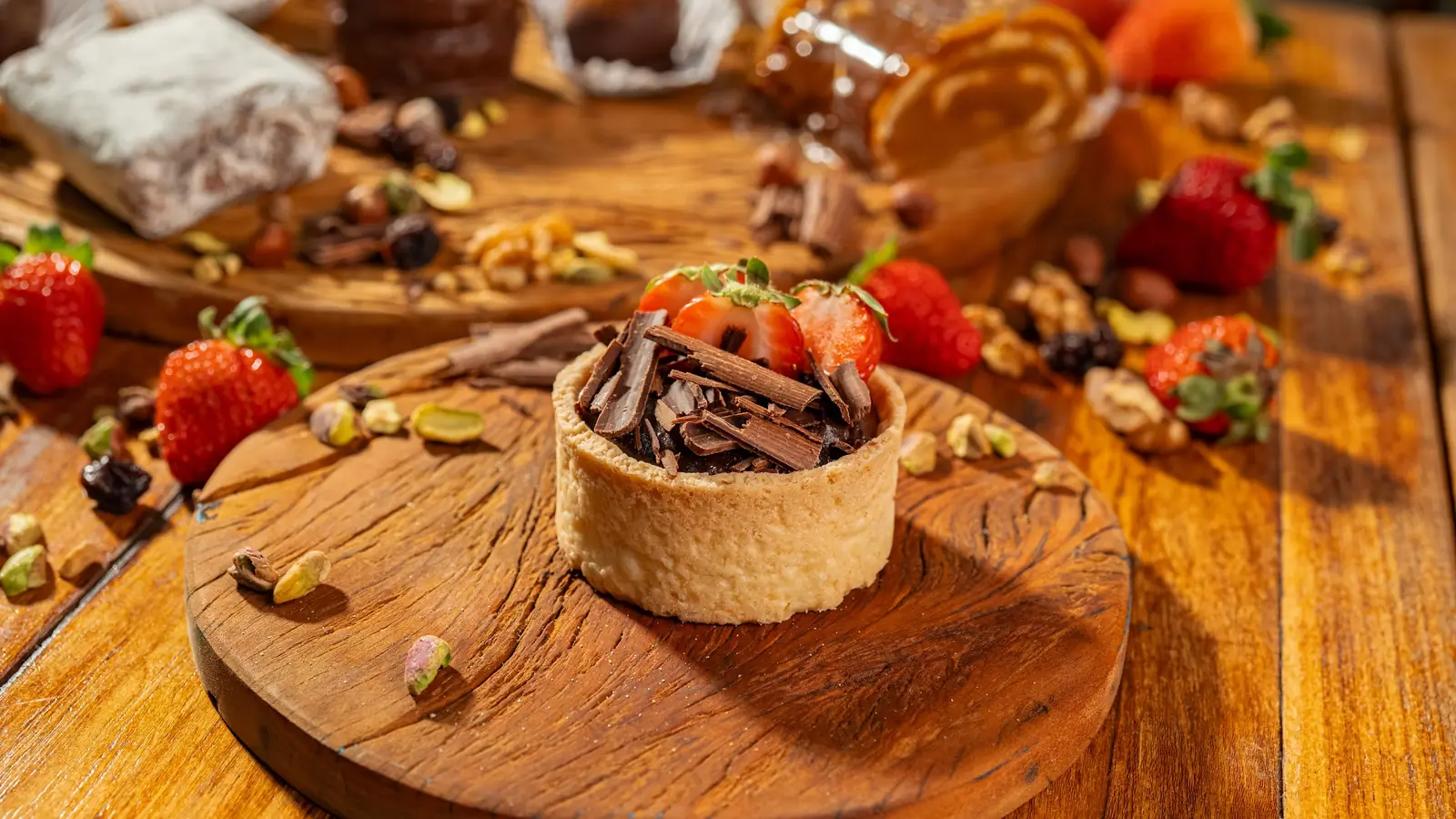 Tarteletes de chocolate com morangos sobre tábua de madeira