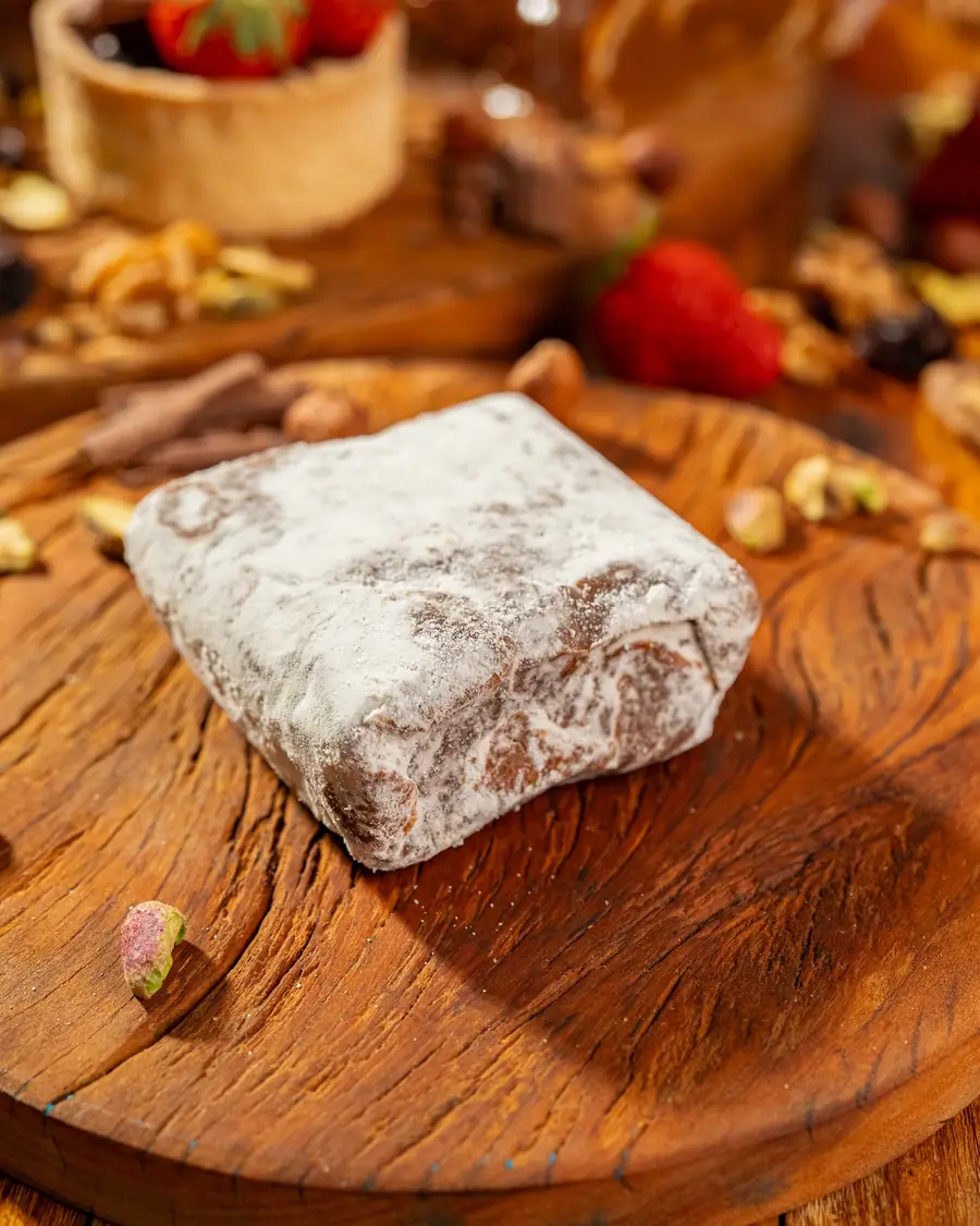 Doce polvilhado com açúcar sobre tábua de madeira